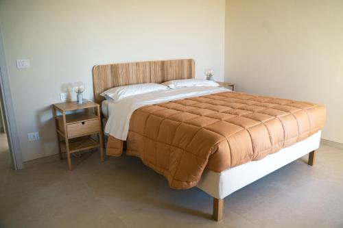 a large bed in a bedroom with a night stand at Masseria Marchesani in Montenero di Bisaccia