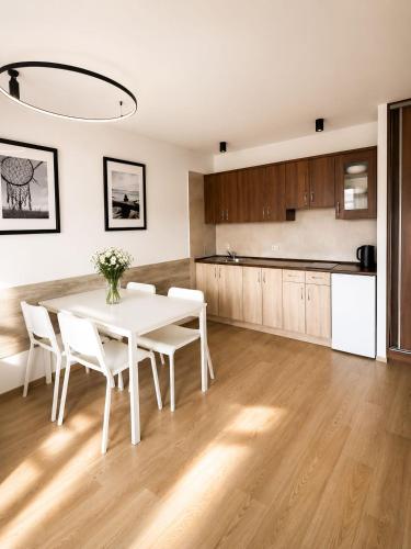 a kitchen and dining room with a white table and chairs at Rowyhills in Rowy