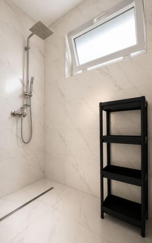 a bathroom with a shower and a black shelf at Rowyhills in Rowy