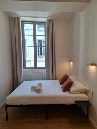 a bedroom with a bed with two towels on it at Studio de charme - Centre Vienne - Proche gare in Vienne