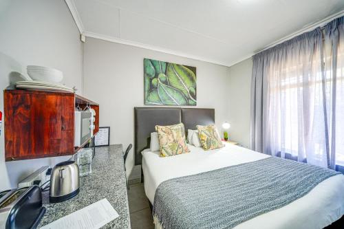 a hotel room with a bed and a window at 13 Hobson in Secunda