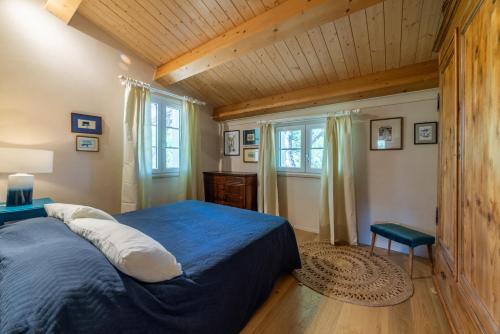 a bedroom with a blue bed and a wooden ceiling at Charme Villa La Vela - Goelba in Lacona