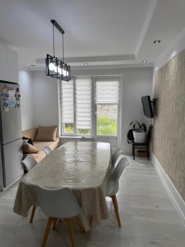 a white dining room with a table and chairs at Гостевой дом 64 in Naryn