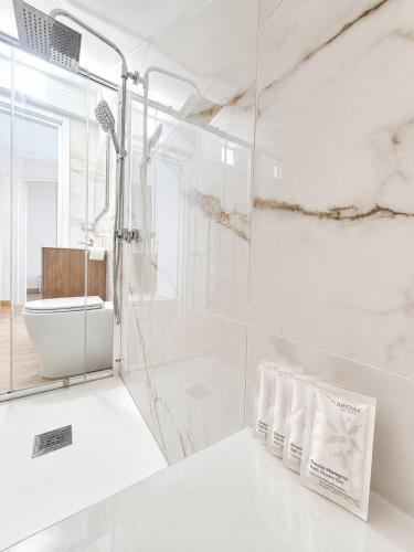 a white bathroom with a shower and a sink at Palazzo Solera in Casarano