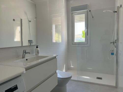 a white bathroom with a sink and a shower at Catalina in Mondariz