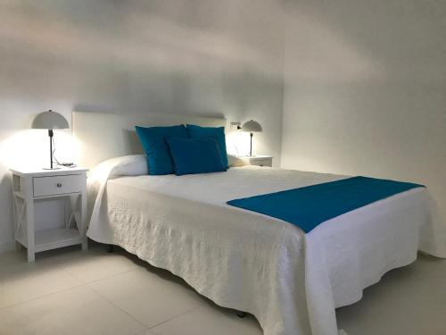 a bedroom with a large white bed with blue pillows at Catalina in Mondariz
