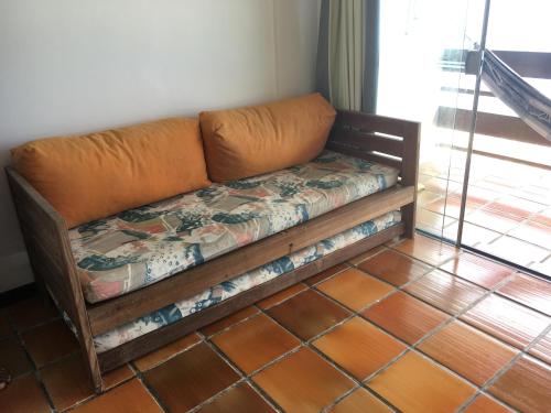 a couch sitting in the corner of a room at Dúplex Frente Mar na ilha de Itaparica in Vera Cruz de Itaparica