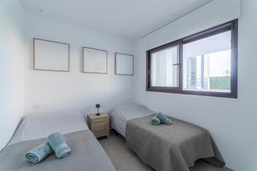 a bedroom with two beds and a window at LA Paz - Sunny Pool Retreat - Jacuzzi - Near Beach in Los Alcázares