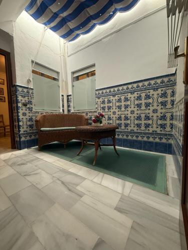 a living room with blue and white walls and a table at Hotel La Española in Chipiona