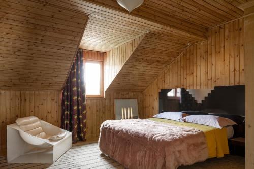 a bedroom with a large bed and a chair at Herbighe Retreat in Asiago