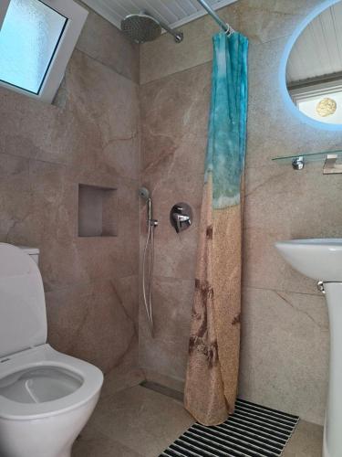 a bathroom with a shower with a toilet and a sink at Cleopatra Apartments in Laganas