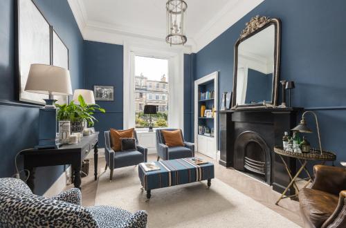 a living room with blue walls and a mirror at West End Townhouse in Edinburgh