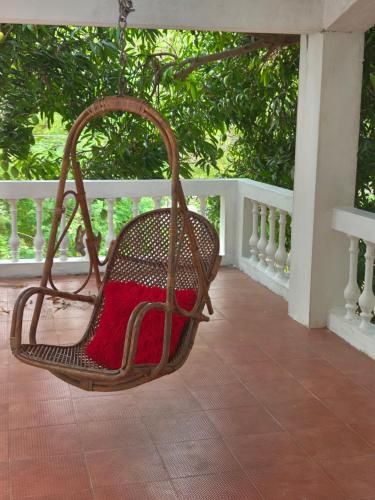 a wicker chair sitting on a porch at AUM VILLA Homestay in Pondicherry and Auroville in Puducherry Airpoert