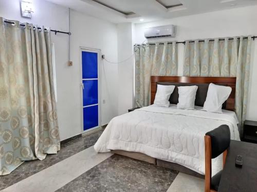 a bedroom with a large bed and a window at Naira and Kobo Hotel in Umuahia