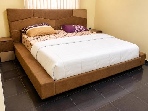 a large bed with two pillows on top of it at Kays Royal Suite in Isasi