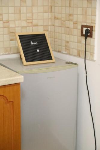 a laptop computer sitting on top of a refrigerator at Prim Guest House in Këlcyrë