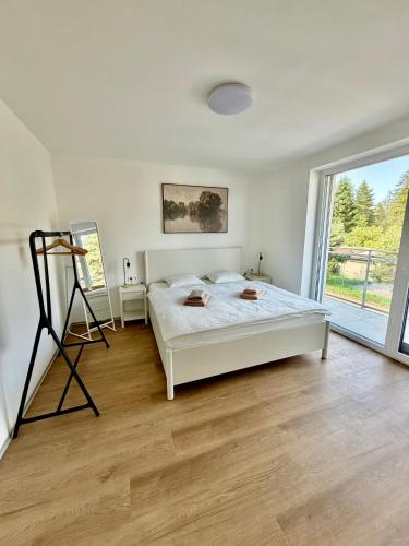 a bedroom with a white bed and a large window at Ager Apartments Poprad in Poprad