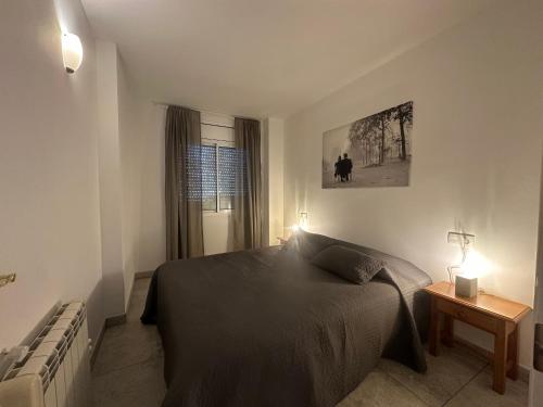 a bedroom with a bed and a table and a window at Teresita 2 in Empuriabrava
