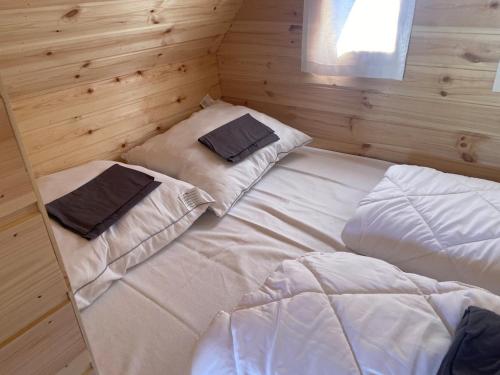 a bedroom with two beds in a wooden wall at Rustical deluxe - Hexenhäuschen in Echternacherbrück