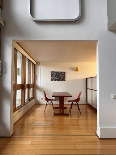 a dining room with a table and two chairs at Le Corbusier Expérience in Firminy