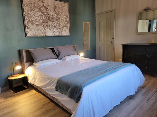 a bedroom with a large white bed and a dresser at Lazy Tilapia in Baie du Tombeau