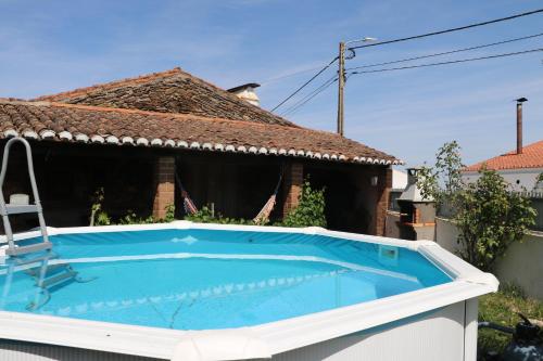 a swimming pool in front of a house at C M Casa de Mares Alojamento Local in Casas Novas de Marés