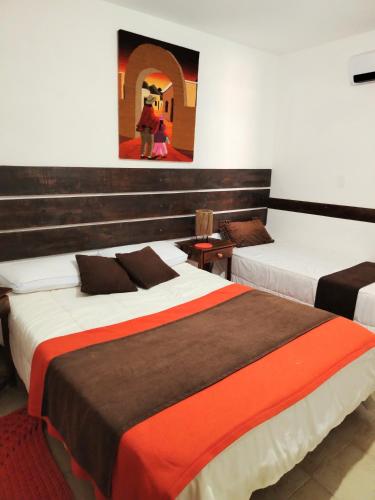 a hotel room with two beds and a painting on the wall at Casita Tafí del Valle in Tafí del Valle