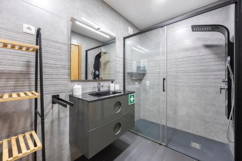 a bathroom with a sink and a glass shower at T1 Morderno - Alvor in Alvor