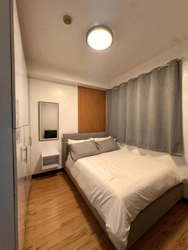 a bedroom with a large bed with a window at MK Suites CDO in Pontud