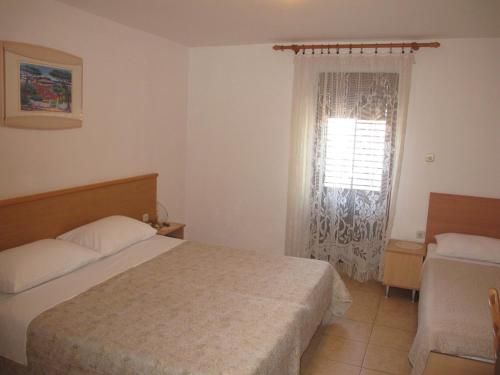 a hotel room with a bed and a window at Apartments Roza in Rošini