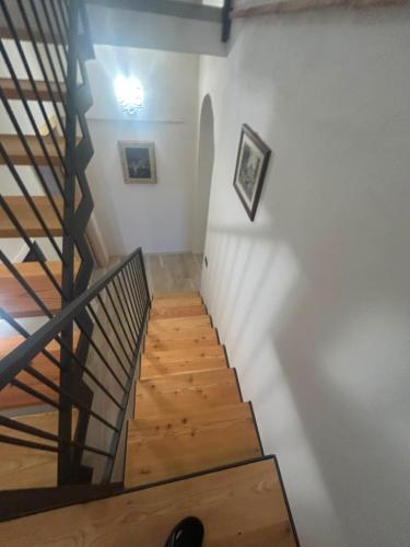 eine Treppe in einem Raum mit weißen Wänden und Holzböden in der Unterkunft Residenze del Borgo - Ca de Paciu in Crociglia