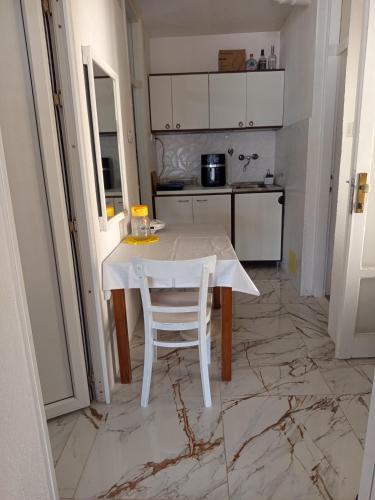a kitchen with a white table and a white chair at Mina in Krašići