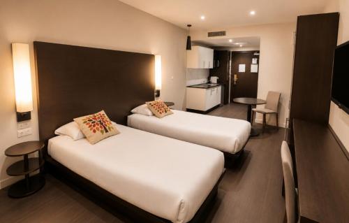 a hotel room with two beds and a kitchen at Résidence Les Alizés Bordeaux Sud - La Brède in La Brede