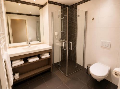 a bathroom with a sink and a shower and a toilet at Résidence Les Alizés Bordeaux Sud - La Brède in La Brede