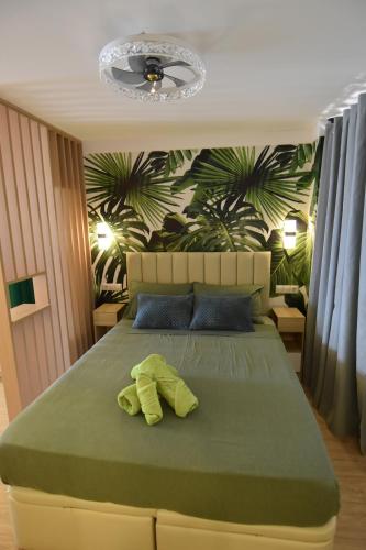 a bedroom with a green bed with a green leafy wall at Resort Villa Playa in Roquetas de Mar