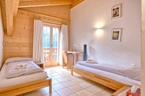 a bedroom with two beds and a window at Apartment Brunnen - GRIWA RENT AG in Grindelwald
