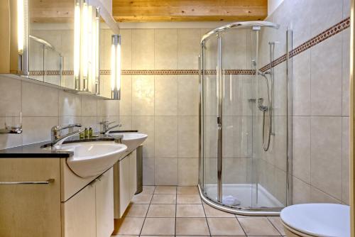 a bathroom with a shower and a sink and a toilet at Apartment Brunnen - GRIWA RENT AG in Grindelwald