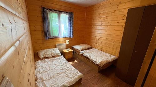 a room with two beds in a wooden cabin at Chata U malého Janka in Bojnice