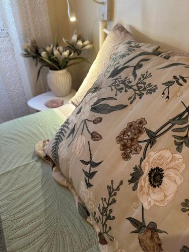 Ein Kissen mit Blumenmuster liegt auf einem Bett. in der Unterkunft Central Spot 9 in Korfu-Stadt