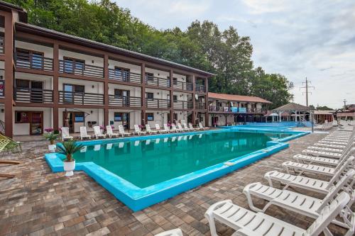 a swimming pool with chairs and a building at Dallas in Solotvyno