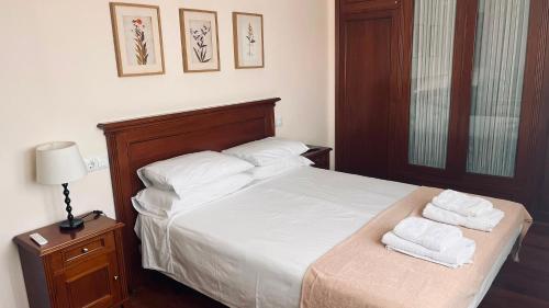 a bedroom with a bed with two towels on it at LA BUGANVILLA in Gijón