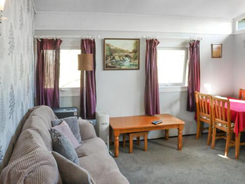 a living room with a couch and a table at Noddfa in Newcastle Emlyn