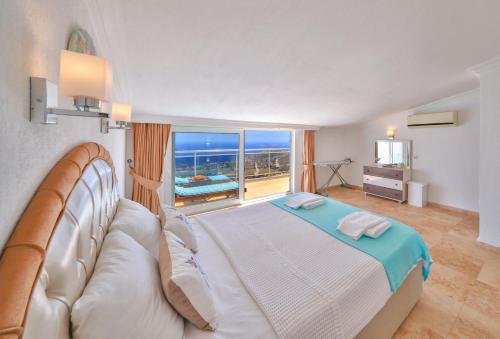 a bedroom with a bed and a large window at Apollon Apartment in Kalkan
