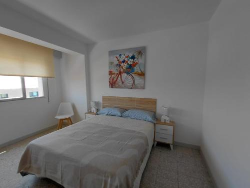a bedroom with a bed and a painting on the wall at Pedra Pateira 1 in Ribeira