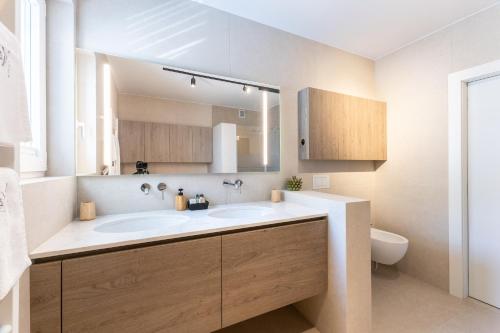 a bathroom with a sink and a mirror and a toilet at LUX Dolce Vista Apartment - Portorož in Portorož