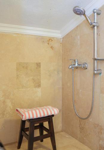 a shower with a stool in a bathroom at Apollon Apartment in Kalkan