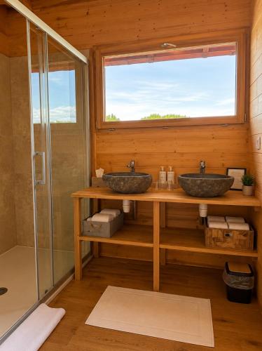 two sinks in a bathroom with a window at Le Domaine de La Tour des Vents in Bergerac