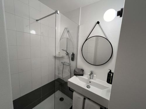 a white bathroom with a sink and a mirror at ibis Alençon in Alençon