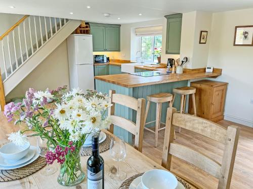 a kitchen and dining room with a table with flowers at The Dairy - Uk50427 in Malton