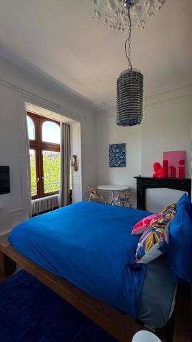 a bedroom with a blue bed and a window at Hi bed & breakfast Liège in Liège